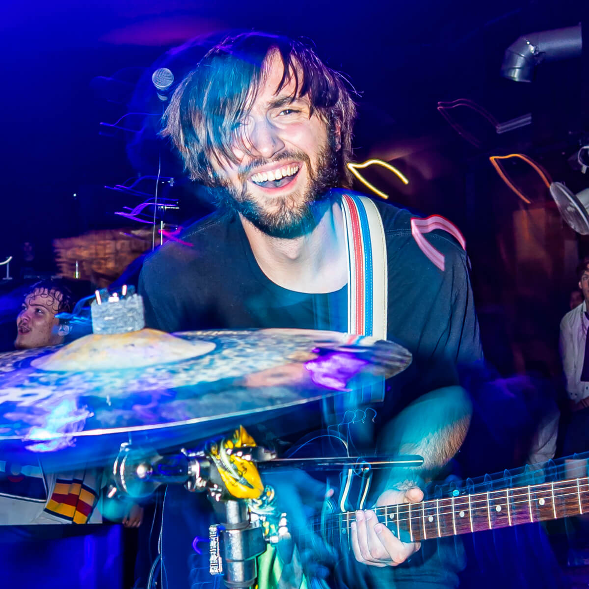 Image of Jack Stoker holding his guitar and smiling at the camera.